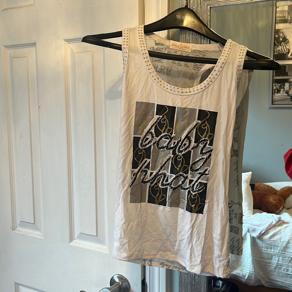 White camisole with black and gold details. Elastic fabric